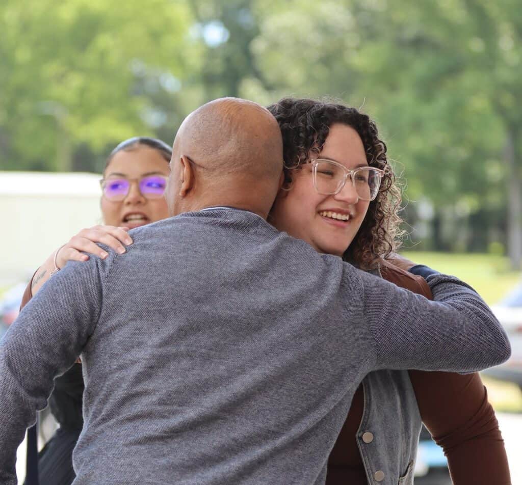 A man and a woman from Lifehouse Church in Newport News, VA greet each other with a hug